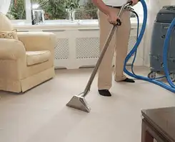 Carpet cleaning professional removing dirt and stains with a hot-water extraction tool in a home, Long Beach, CA.