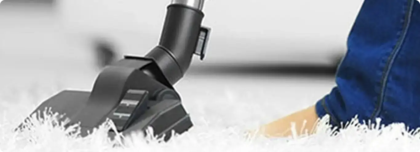 Close-up of a professional vacuuming a white carpet in Lakewood.